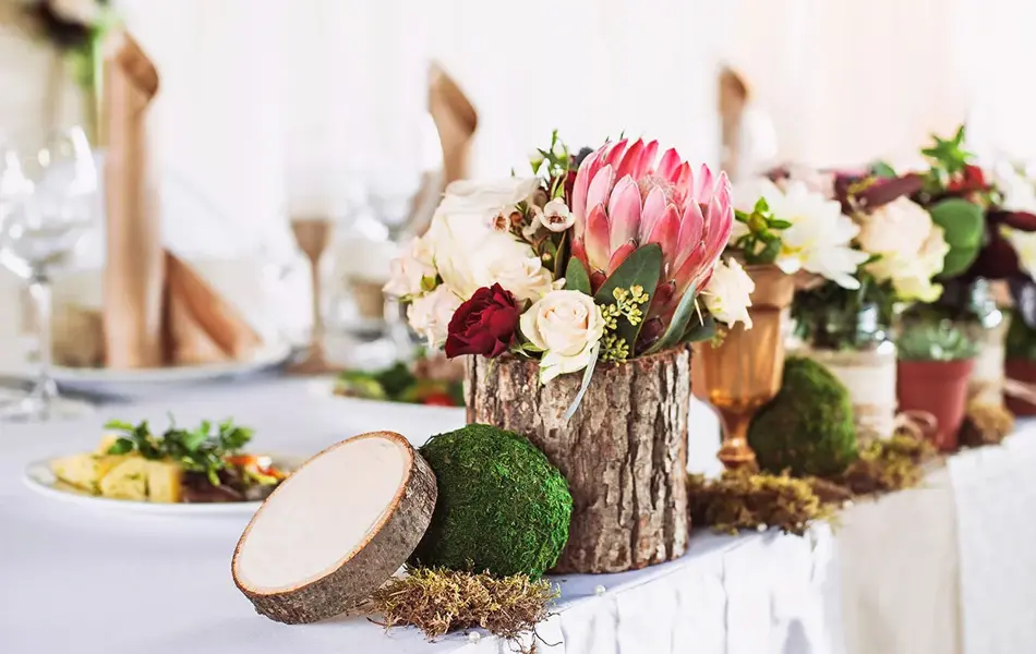 Borddekorasjon av bark og diverse blomster