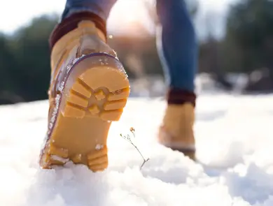 Nærbilde av vintersko som går på snø 