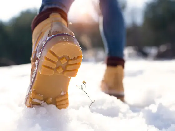 Nærbilde av vintersko som går på snø 