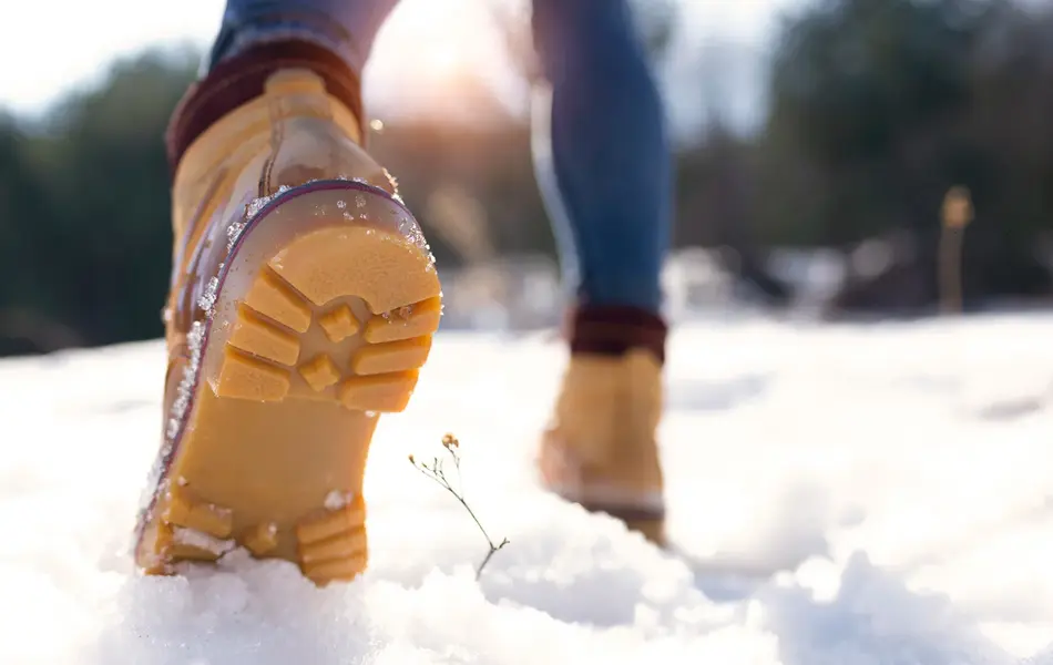 Nærbilde av vintersko som går på snø 