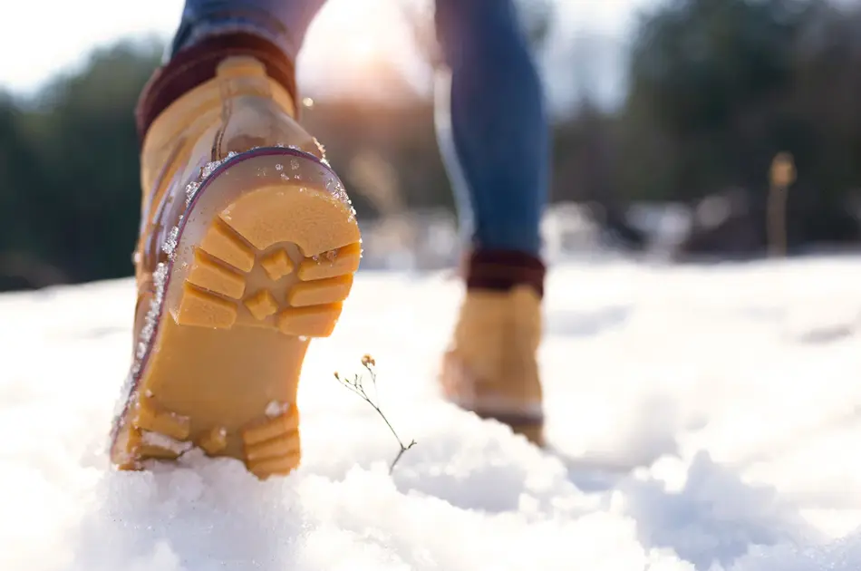 Nærbilde av vintersko som går på snø 