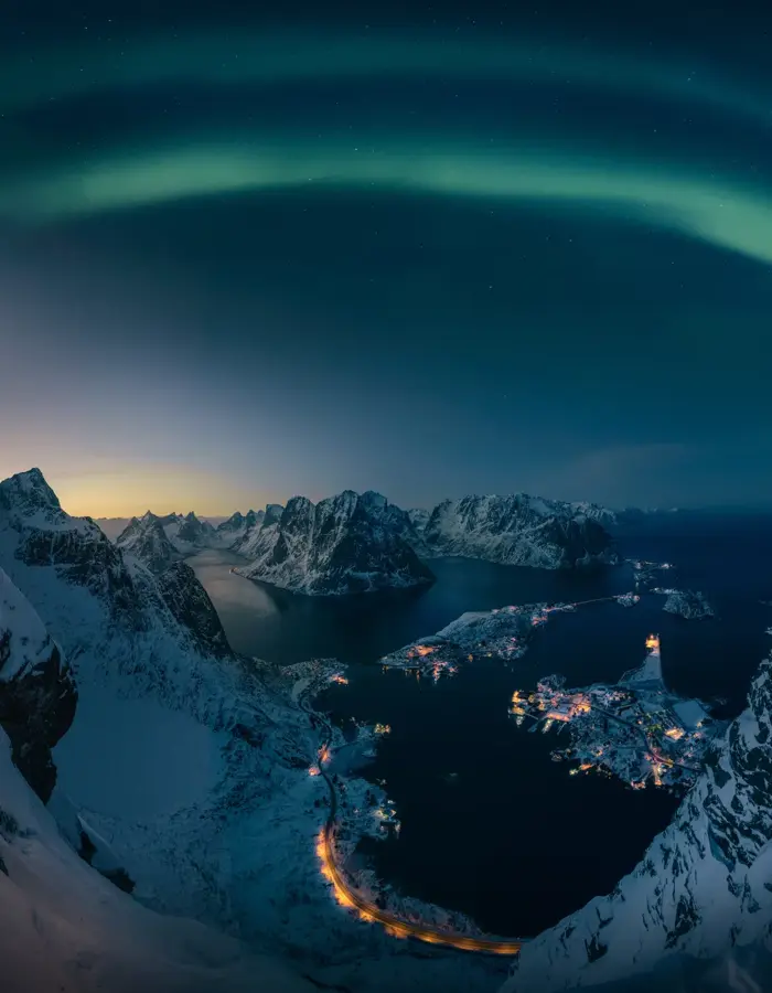 Man skuer utover vakkert nordlys fra Reinebrigen i Lofoten