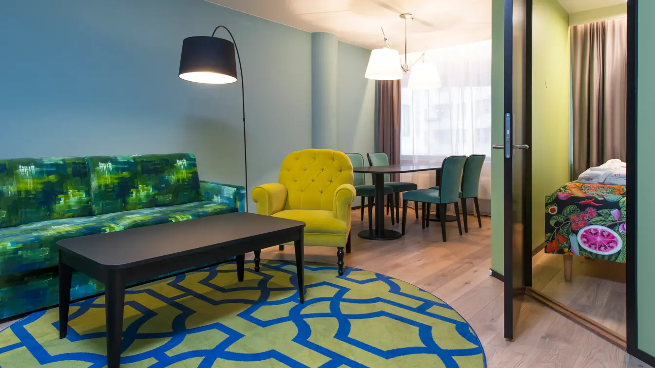Sofagruppe, spisebord og dør inn til separat soverom i juniorsuite på Thon Hotel Vika Atrium i Oslo