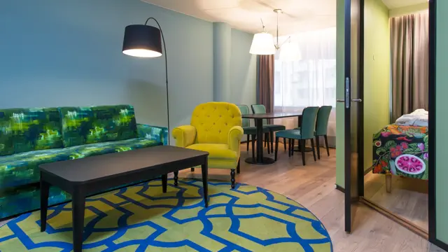 Sofagruppe, spisebord og dør inn til separat soverom i juniorsuite på Thon Hotel Vika Atrium i Oslo