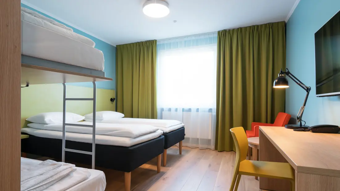 Dobbeltseng, køyeseng og skrivebord i familierom på Thon Hotel Gardermoen
