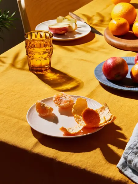 Oppdekket bord med gul duk og frukt