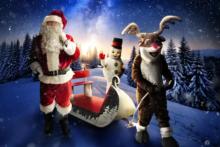 Julenissen, reinsdyr og snømann med slede mellom seg