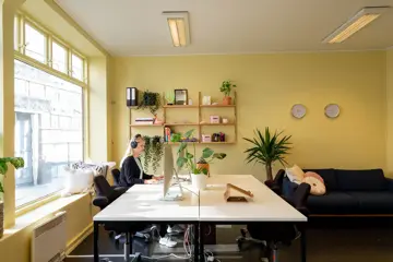 Interiør fra kontoret til Vild, med store vinduer og gule vegger.