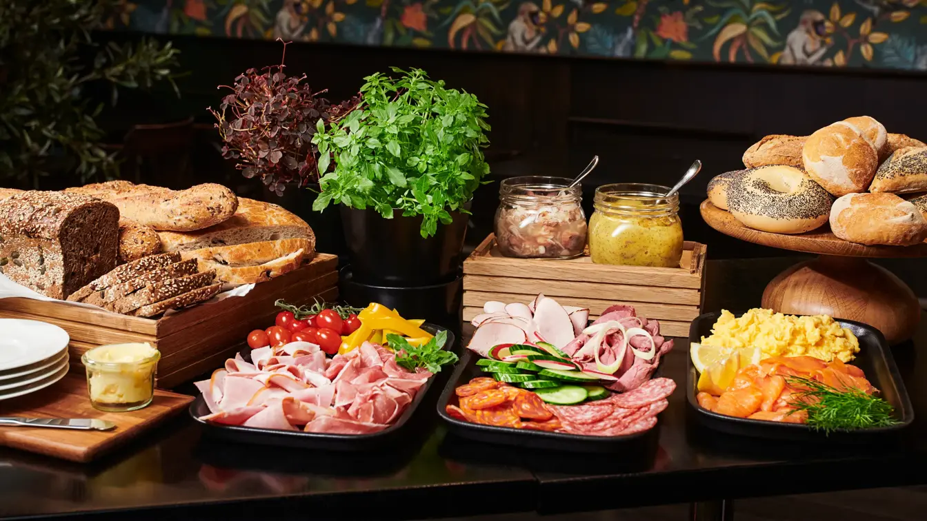 Brød, smør, ulike varianter kjøttpålegg, røkt laks, eggerøre, rundstykker, sennepsild, sild, krydderplanter