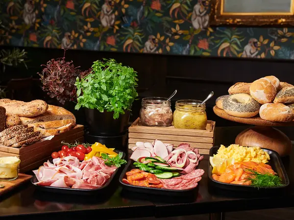 Brød, smør, ulike varianter kjøttpålegg, røkt laks, eggerøre, rundstykker, sennepsild, sild, krydderplanter