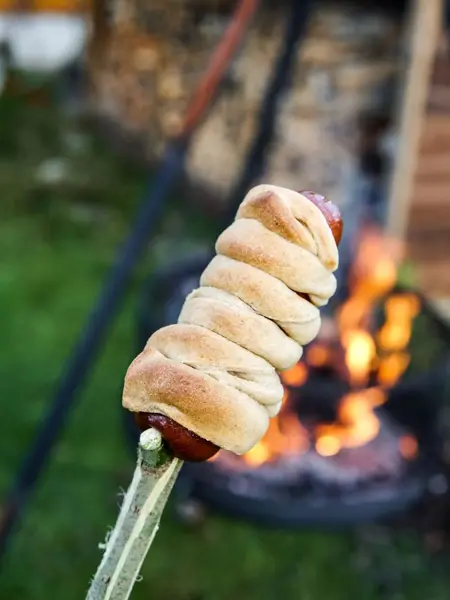 pølser og pinnebrød foran bål