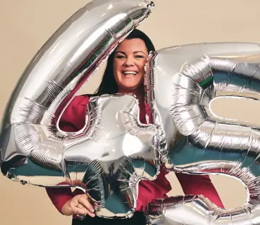 Elisabeth som holder folieballonger med nummerene nr "4" og "5"