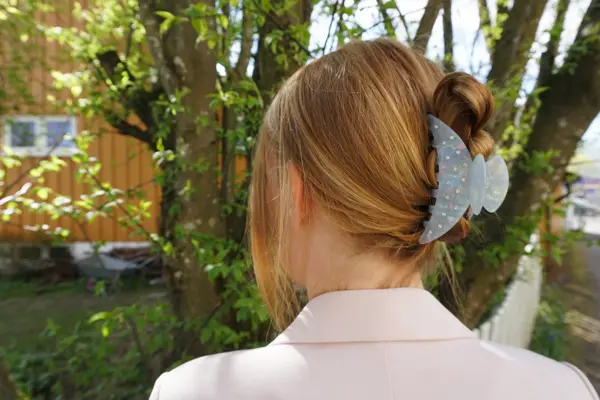 Nærbilde av kvinne med håret satt opp av hårklype, sett bakfra