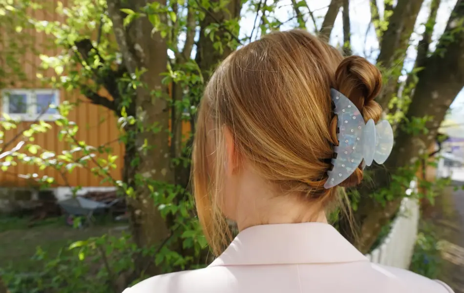 Nærbilde av kvinne med håret satt opp av hårklype, sett bakfra