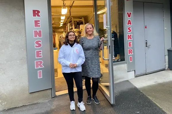 To damer som står utenfor butikken renseri