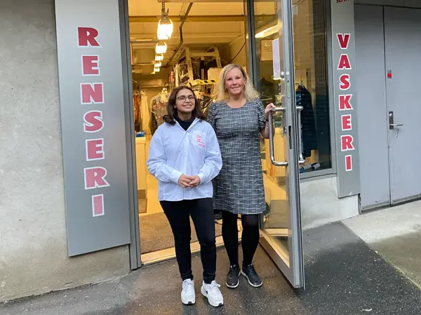 To damer som står utenfor butikken renseri