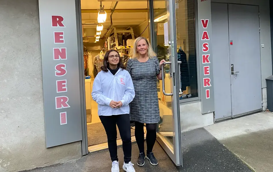 To damer som står utenfor butikken renseri