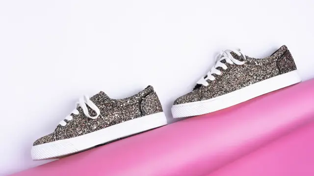 Glitrende sneakers mot en hvit og rosa bakgrunn