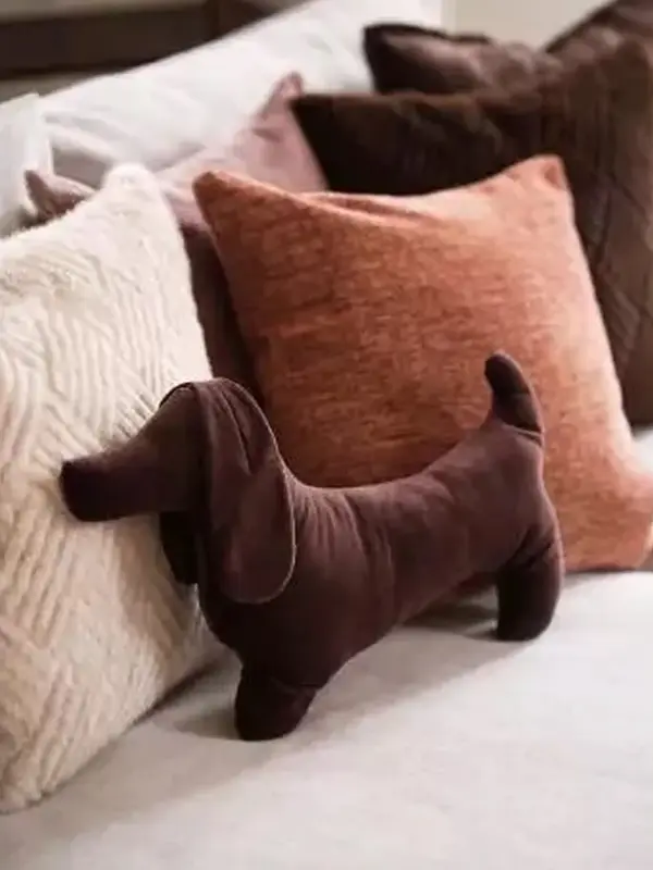 Pute formet som en dachs i en sofa