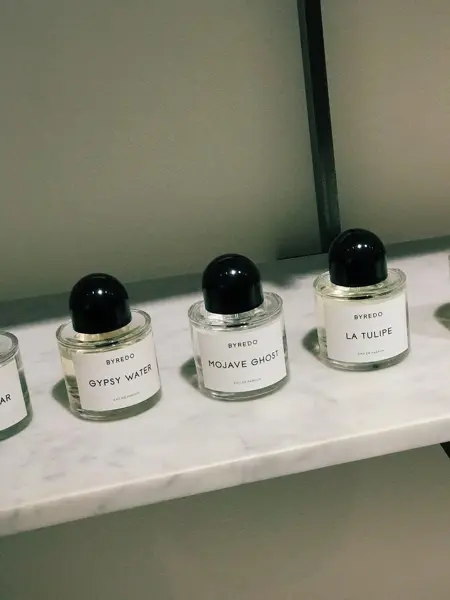 Nærbilde av flere parfymeflasker på rekke