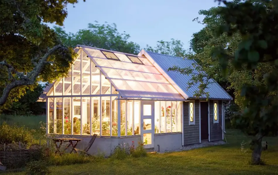 Belyst drivhus i skumringen