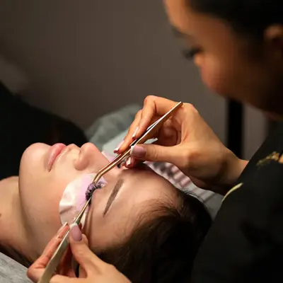 dame som setter på løsvipper på en annen dame