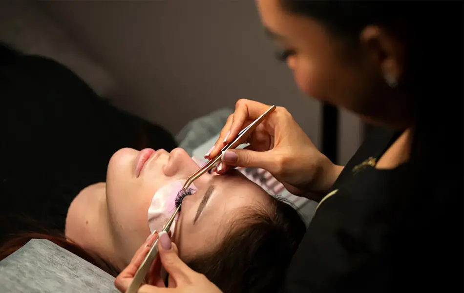 dame som setter på løsvipper på en annen dame