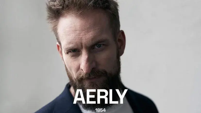 Mann med skjegg ser i kamera, teksten Aerly 1854 står nederst i bildet