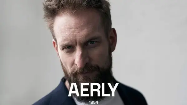 Mann med skjegg ser i kamera, teksten Aerly 1854 står nederst i bildet