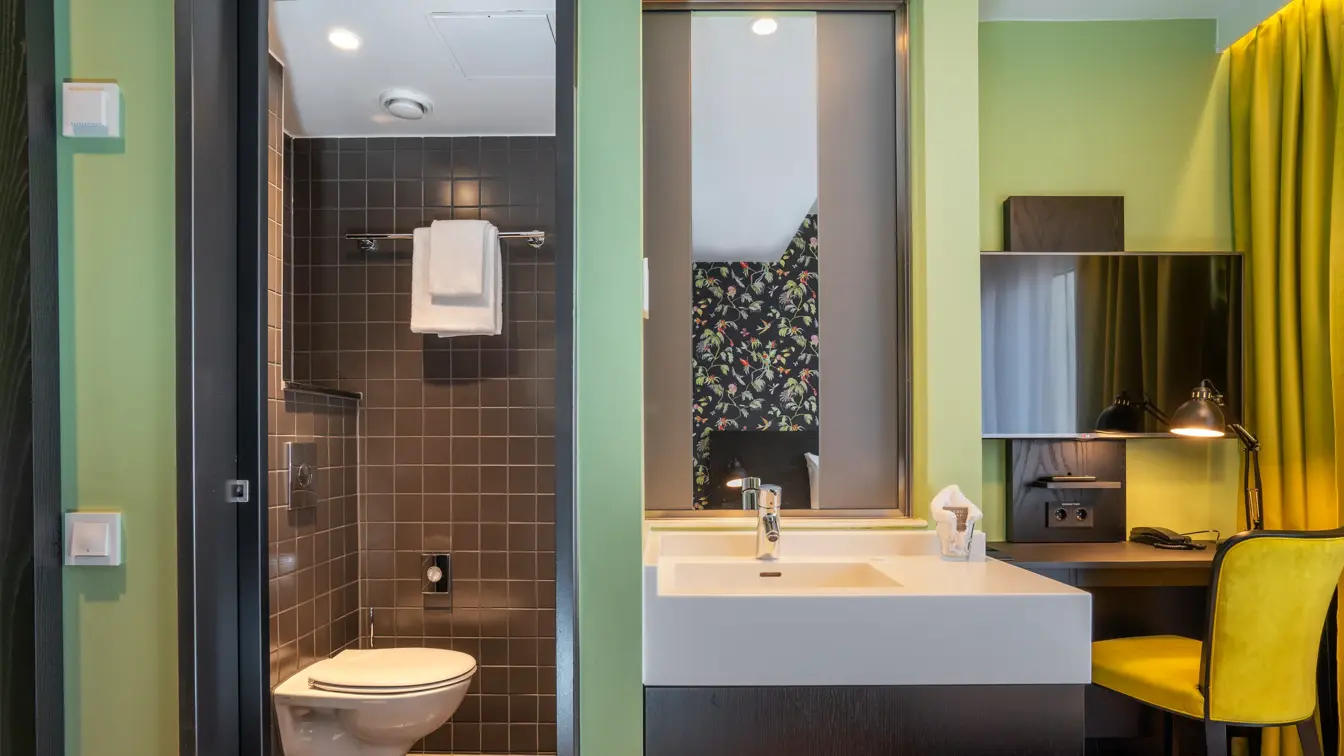 Bad, vask og skrivebord på enkelt rom på Thon Hotel Gyldenløve i Oslo