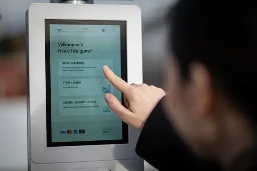 En kvinne som trykker på P-automaten 