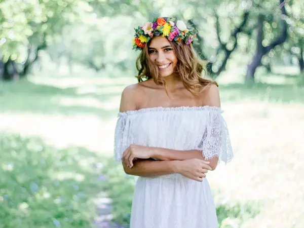 kvinne ute i hvit blondekjole og blomsterkrans