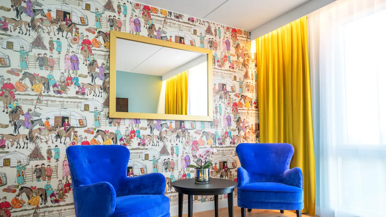 Dekorativ tapet, speil med gullramme og to sitteplasser rom på Thon Hotel Storo