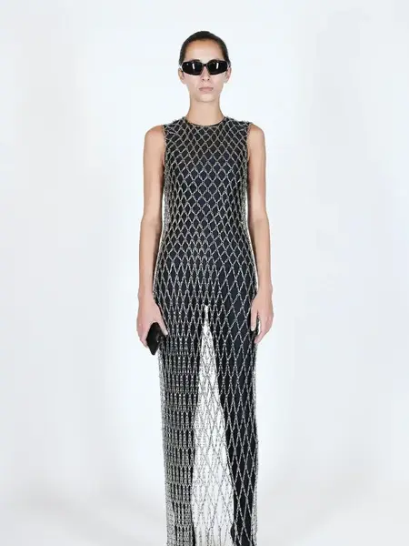 Dame i sort tettsittende drakt med en sølvfarget nettingkjole over