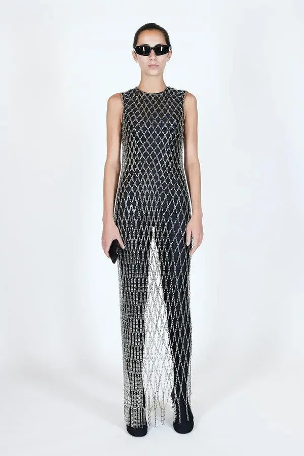 Dame i sort tettsittende drakt med en sølvfarget nettingkjole over