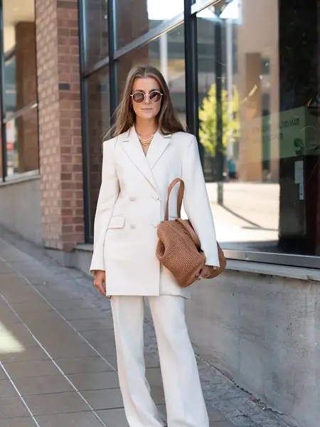 Ung kvinne som poserer i hvit dress