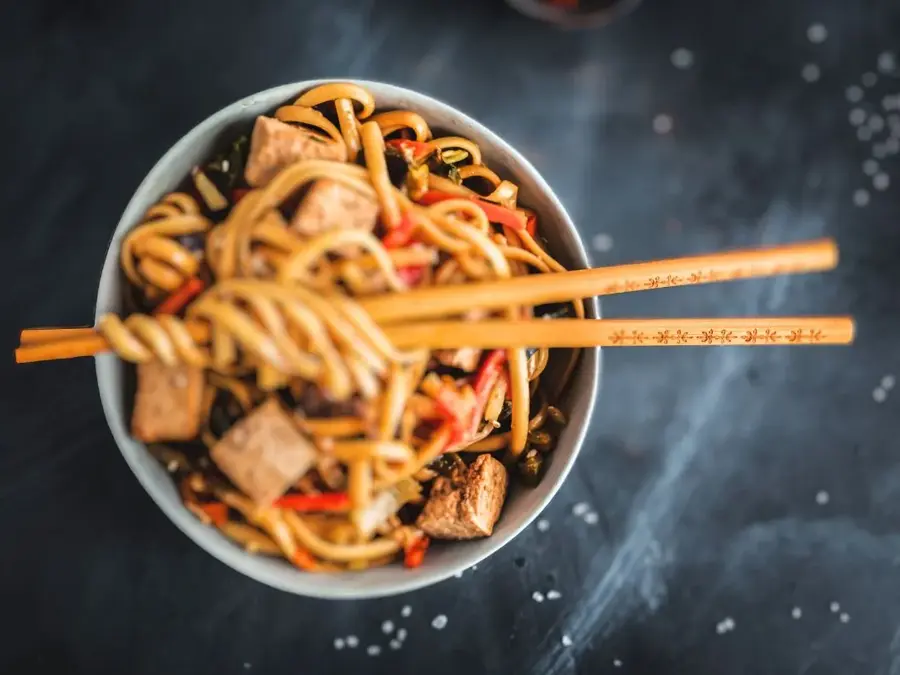 Asiatiske nudler i tallerken med spisepinner