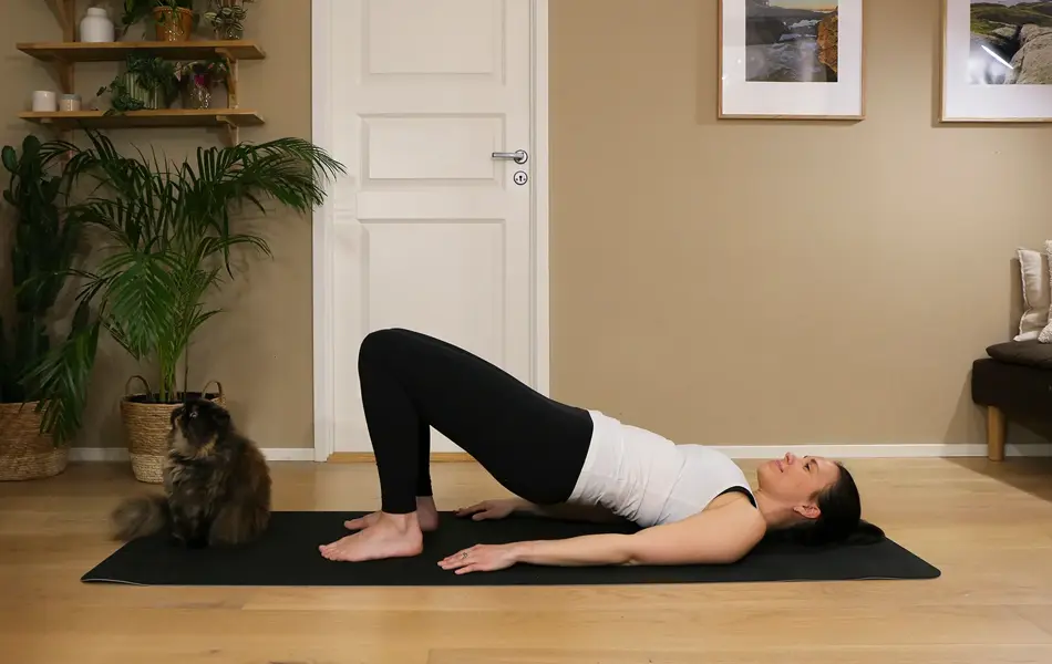 Anna viser Pilates-øvelser på treningsmatte på gulvet