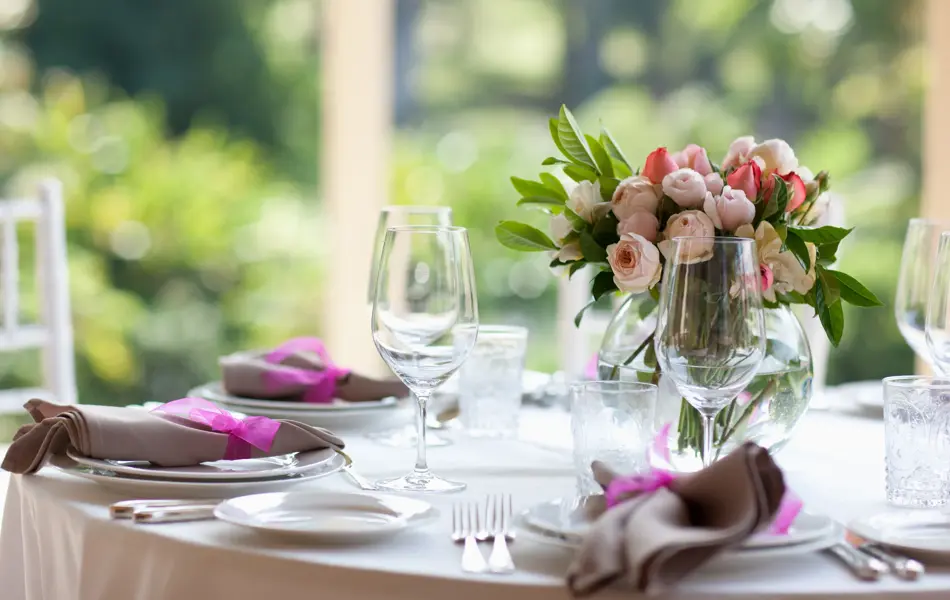 Bukett med peoner på et dekket, rundt bord