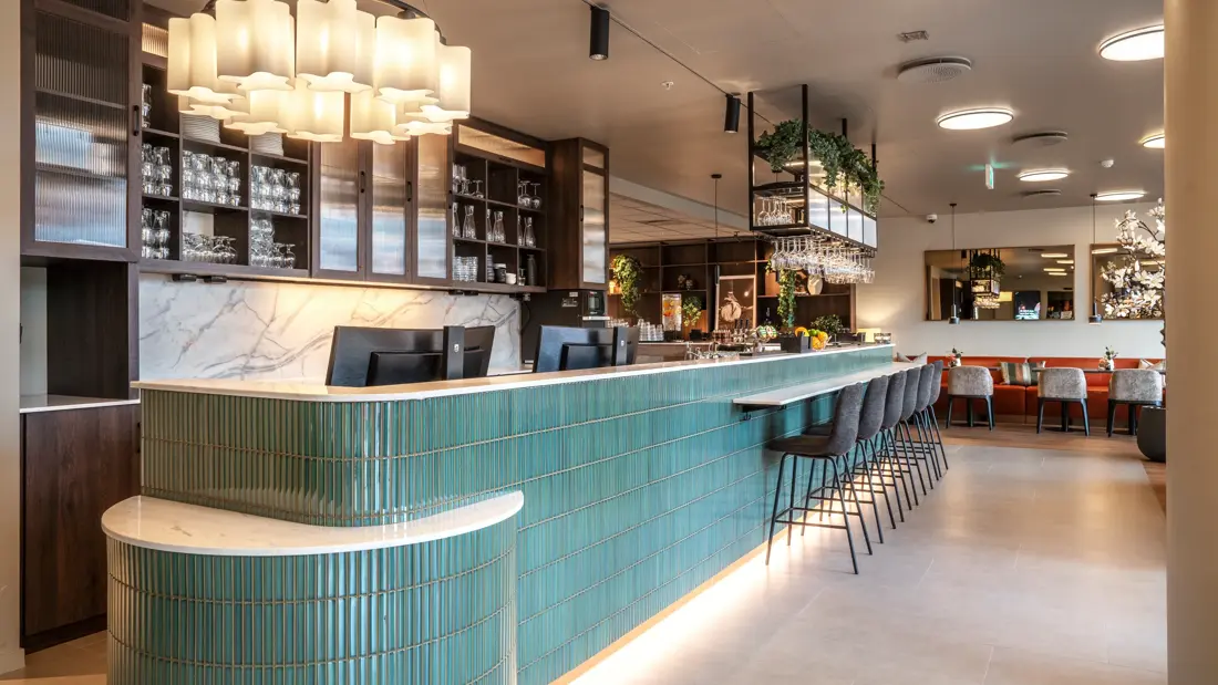 Grønn resepsjonsdisk og lobby bar i lobbyområde