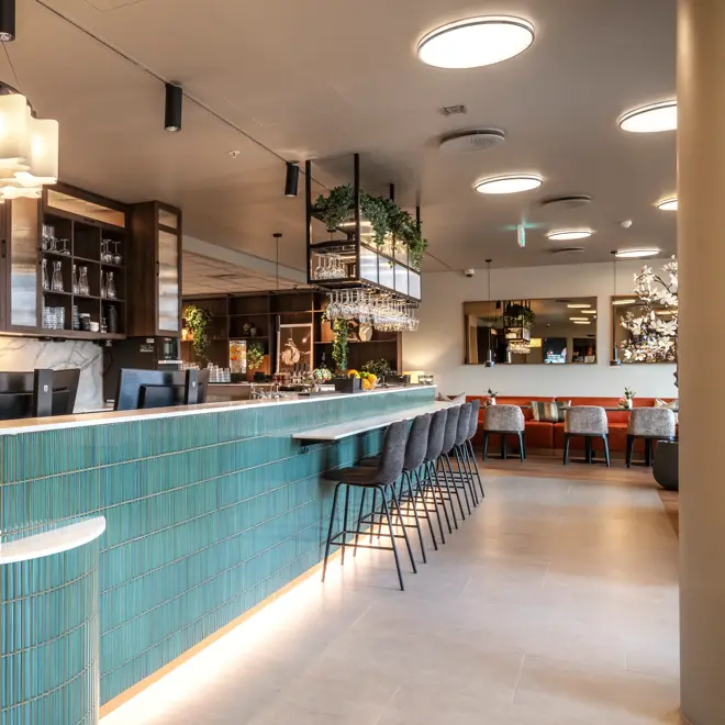 Grønn resepsjonsdisk og lobby bar i lobbyområde