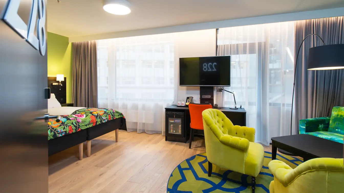 Seng, skrivebord sofagruppe og smart-TV i superiorrom på Thon Hotel Vika Atrium i Oslo