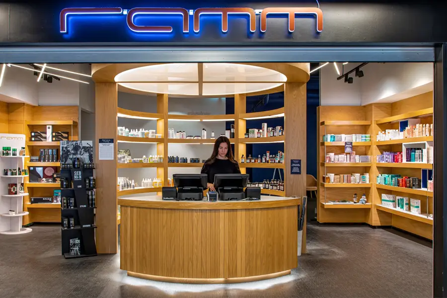 inngang til ramm frisør med masse hårprodukter i hyllene bak