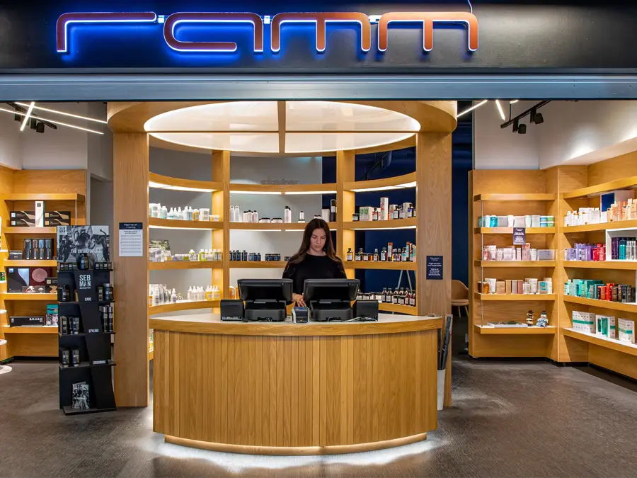 inngang til ramm frisør med masse hårprodukter i hyllene bak