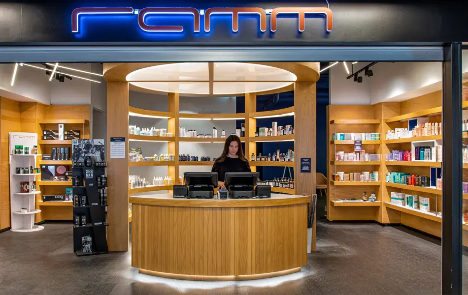 inngang til ramm frisør med masse hårprodukter i hyllene bak