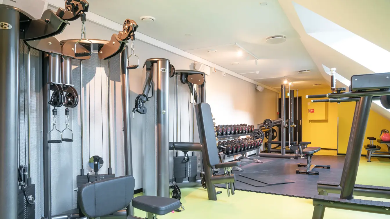Lyse lokaler med gule gulv, treningsapparater i treningsrom på Thon Hotel Spectrum i Oslo sentrum