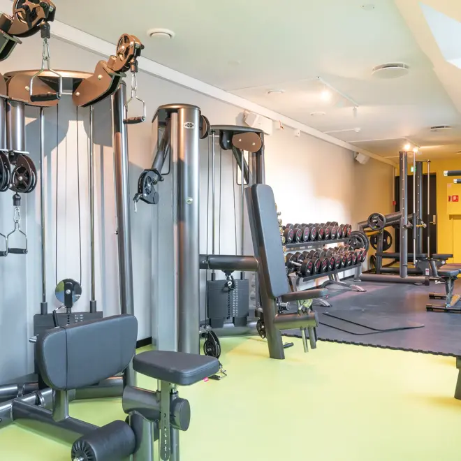Lyse lokaler med gule gulv, treningsapparater i treningsrom på Thon Hotel Spectrum i Oslo sentrum