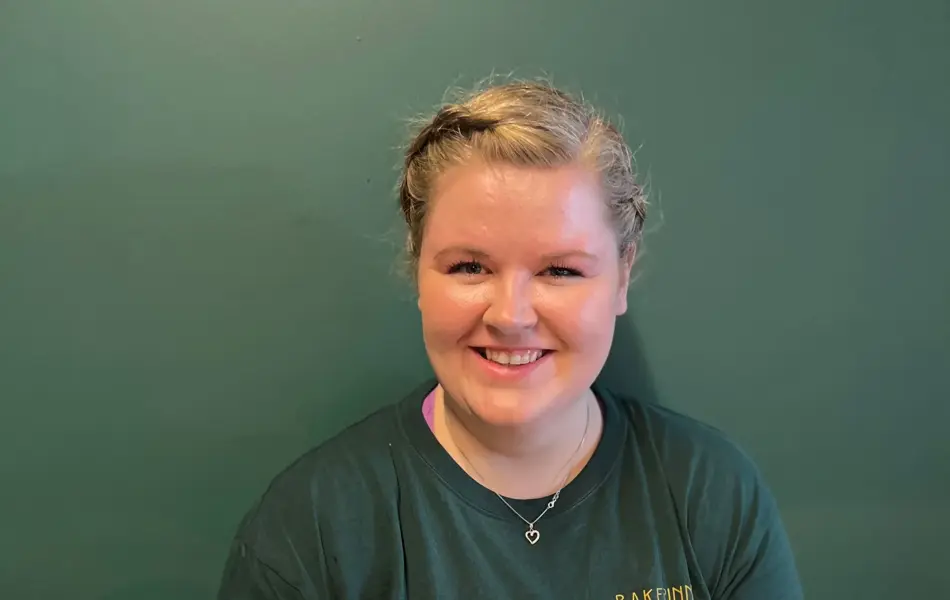 En dame holder en stor, hvit kake