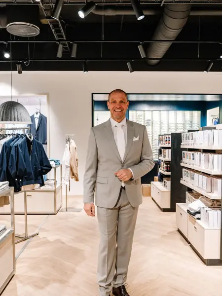 mann i dress står i butikk