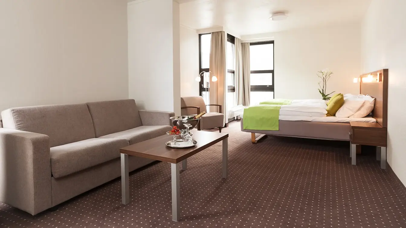 Soffa og seng i rom på Thon Hotel Otta